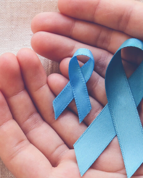 Image of 2 hands holding blue ribbons