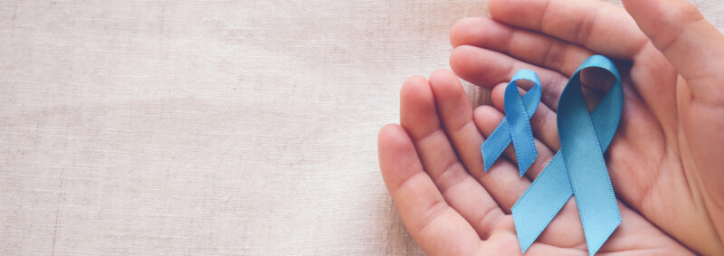 Image of 2 hands holding blue ribbons